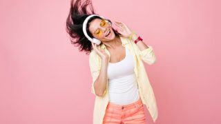 一个快乐的女孩与眼镜,听音乐耳机和舞蹈