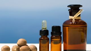 蓝色背景的肉豆蔻油和全干肉豆蔻