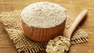 木碗里放天然有机燕麦粉,木勺上放燕麦粉