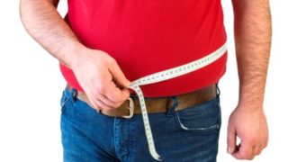 一个测量自己腰围的男人