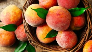 在一篮子成熟的桃子在一个木制的背景