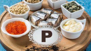 蓝木桌上放着富含磷的食物(红茶、红鱼子酱、松仁、花生、麸皮、切片沙丁鱼、南瓜子和加工过的奶酪)