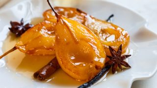 在一个白色板水煮梨与糖浆香料