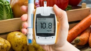 一个拿着读数表的人站在蔬菜箱前