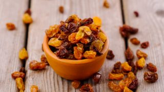 葡萄干的小碗在木桌