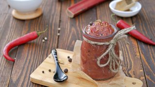 辣大黄酸辣酱酱在玻璃瓶上一个木制的背景