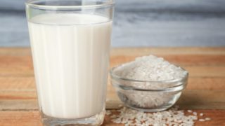 一碗米饭和一杯牛奶放在木制的表面上。