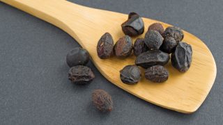 干锯的木匙子在灰色背景的干锯palmetto莓果