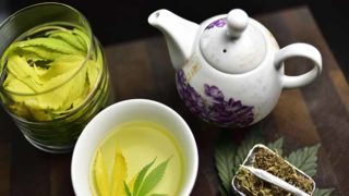 在一碗正在冒烟的茶叶旁边放着一幅正在冒烟的茶的平躺画
