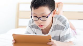 一个小男孩玩自己的平板电脑游戏