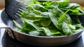 在炉子上用平底锅烹煮新鲜菠菜