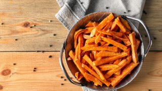 地瓜薯条在一张餐巾纸上一碗上一张木桌