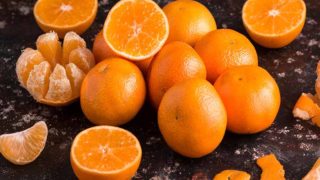 减半,去皮,和一个黑色的表面整个橘子。