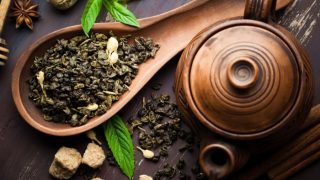 俯视图的茶叶在一个木勺与一个木茶壶旁边