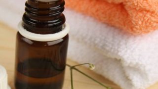 精油一瓶保持旁边一堆白色和橙色毛巾