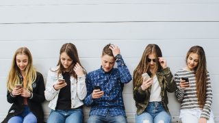 一群青少年坐在户外使用手机