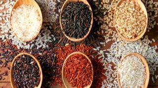 一幅用木勺盛着不同种类大米的平放画