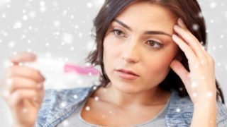 一位拿着验孕棒的妇女看起来很担心