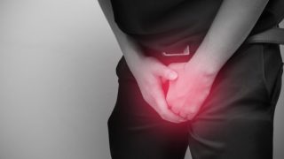 一个患有尿道炎的男人,抱着他的腹股沟