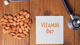 用杏仁做成的心形,白纸上写着“维生素B17”,木纸上写着听诊器