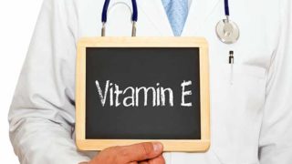 医生拿着听诊器,拿着写着维他命E的牌子