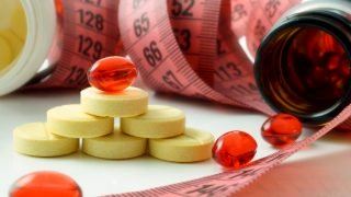 减肥补充剂旁边的测量卷尺