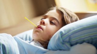 一个患有黄热病的小女孩躺在床上,嘴里还含着一支温度计