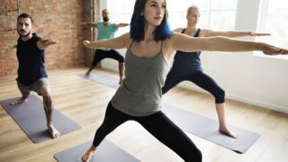 男男女女在瑜伽馆的垫子上练习瑜伽