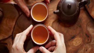 在一套中国茶具里,双手捧着暖暖的育亨贝茶