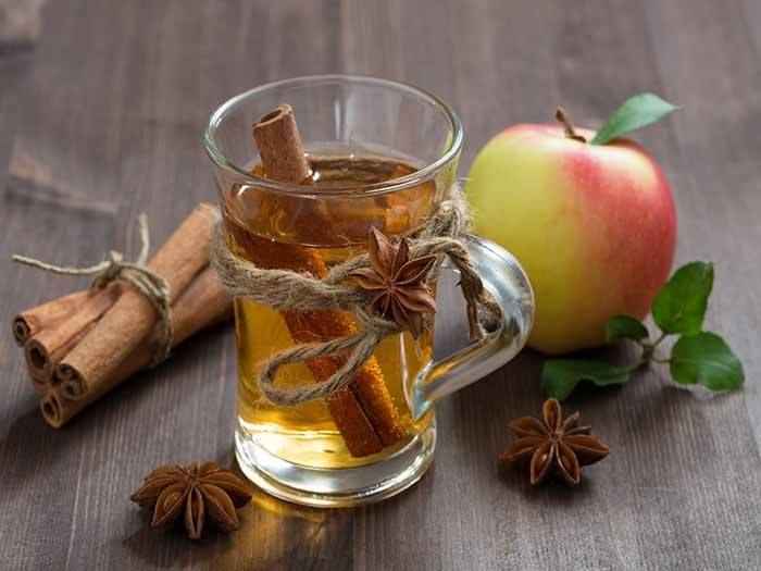 一杯苹果醋茶，以肉桂、八角和苹果为背景