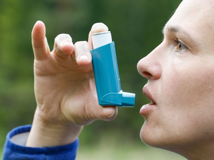 关闭了一个年轻男子的使用哮喘吸入在一个公园