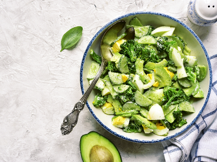 avocado沙拉平面图片加西兰花、黄瓜和煮鸡蛋 白老碗对光板、石碑或混凝土背景