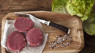 在一个木盘子的北美野牛肉块用烤叉子