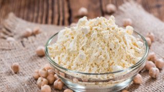 鹰嘴豆粉在一个玻璃碗里用一些鹰嘴豆旁边