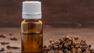 一个丁香油瓶和桌上的几棵丁香