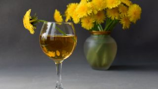 一张桌子上放着一杯蒲公英酒的特写照片