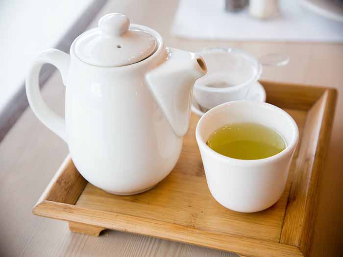 A wooden tray with a teapot and a cup containing gyokuro tea