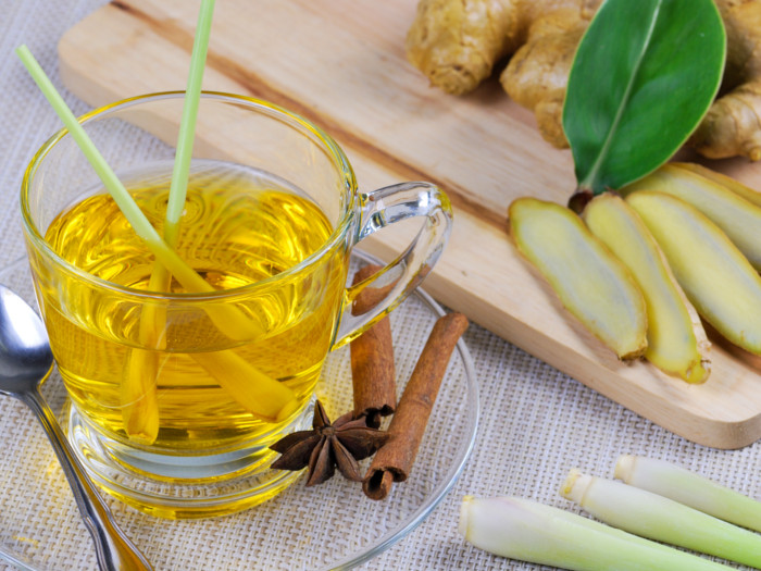 A cup of fresh lemongrass tea and cinnamon and star anise near it