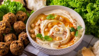 一碗鹰嘴豆，沙拉叶子旁边，沙拉和面包