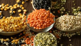 盛在碗和勺子里的各种各样的扁豆