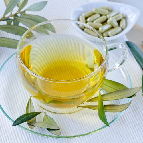 橄榄叶茶，用玻璃杯和碟子盛着橄榄叶，还有一盘补品