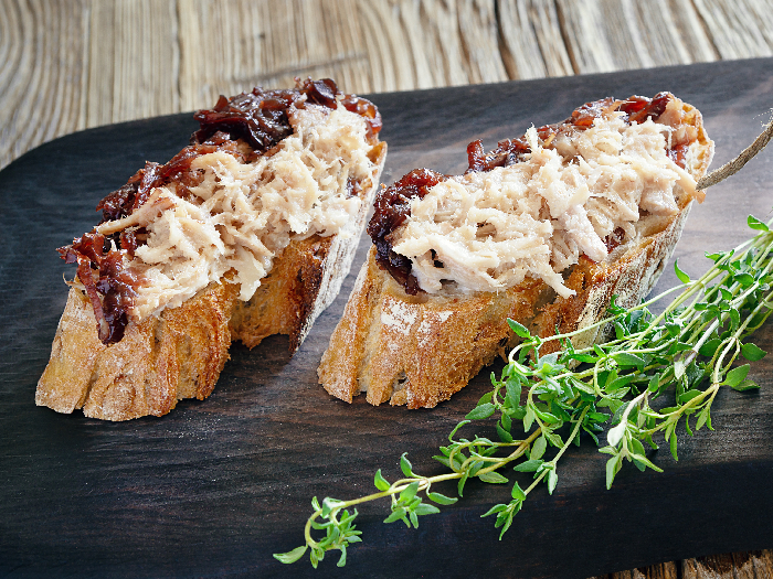 面包上有肉卷，还有一个玻璃罐，上面盖着果酱