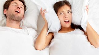 一个男人打鼾和一个女人在他旁边生气